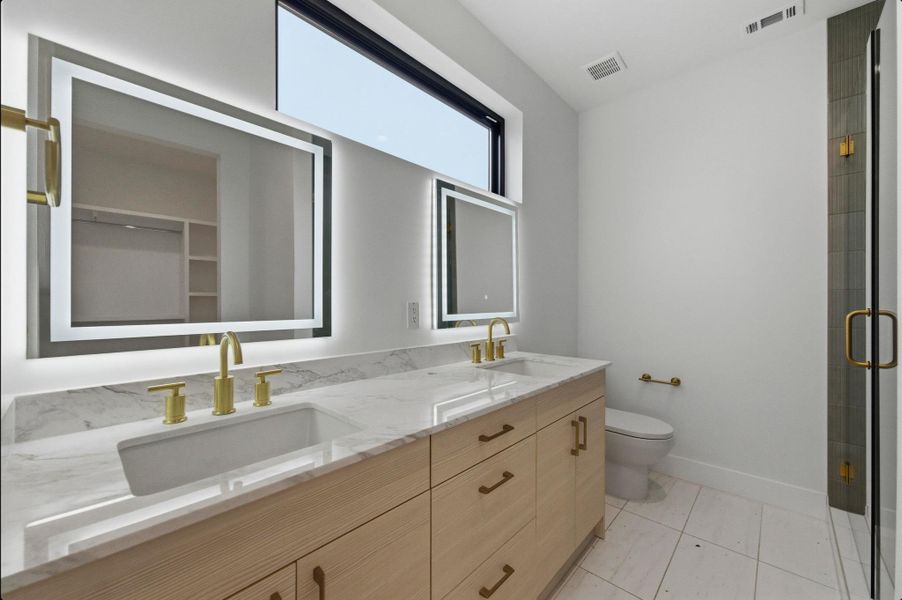 Bathroom featuring double vanity, a stall shower, and light tile patterned floors Bathroom featuring double vanity, a stall shower, and light tile patterned floors