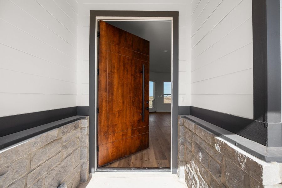 Enter through a rich wood-paneled door into a welcoming interior with durable hardwood flooring. Enter through a rich wood-paneled door into a welcoming interior with durable hardwood flooring.