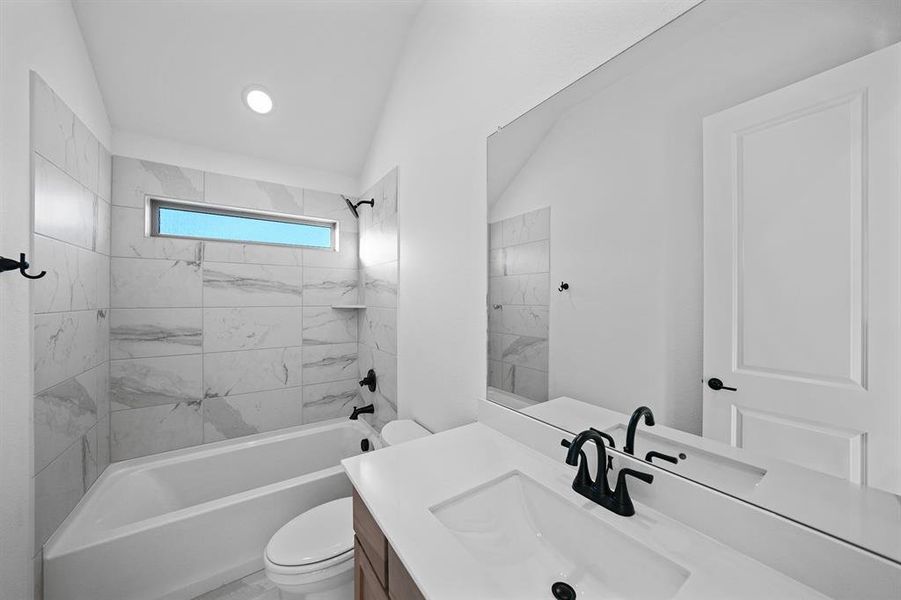 Bathroom with shower / tub combination, vanity, vaulted ceiling, and recessed lighting Bathroom with shower / tub combination, vanity, vaulted ceiling, and recessed lighting