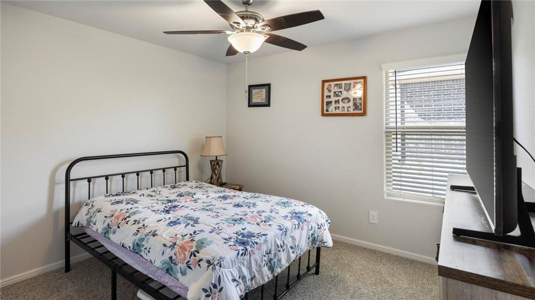 Bedroom with light carpet and a ceiling fan