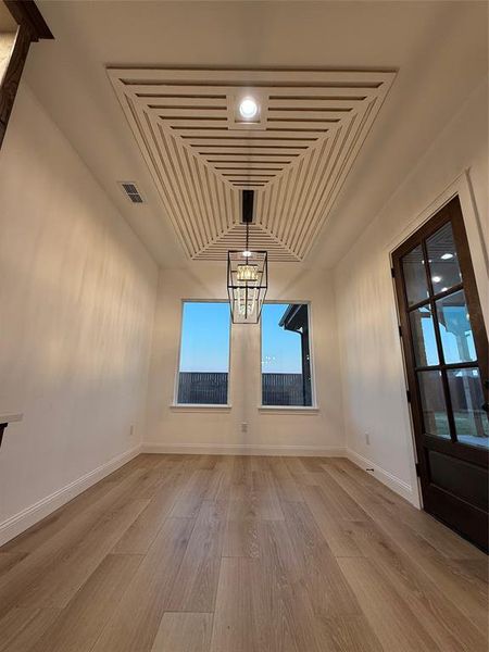 Unfurnished dining area with light wood finished floors and a chandelier Unfurnished dining area with light wood finished floors and a chandelier