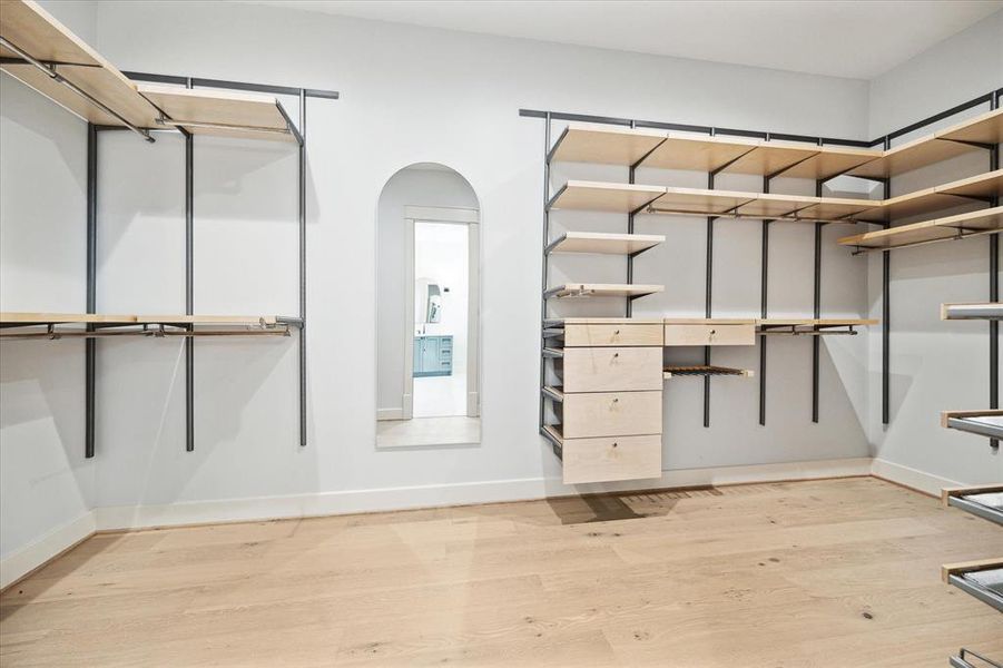 Large walk-in closet with a custom closet system.