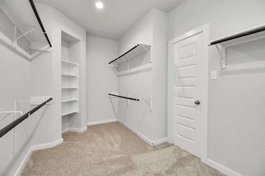 Walk-in closet that epitomizes luxury and practicality. This generously sized space features built-in shelving, offering abundant room for impeccable organization. High ceilings and recessed lighting create a bright and welcoming ambiance..