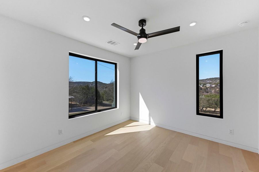 Empty room with ceiling fan, light wood-style floors, and recessed lighting