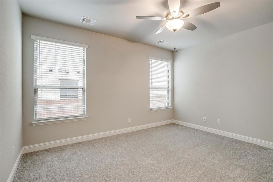 Carpeted spare room featuring ceiling fan