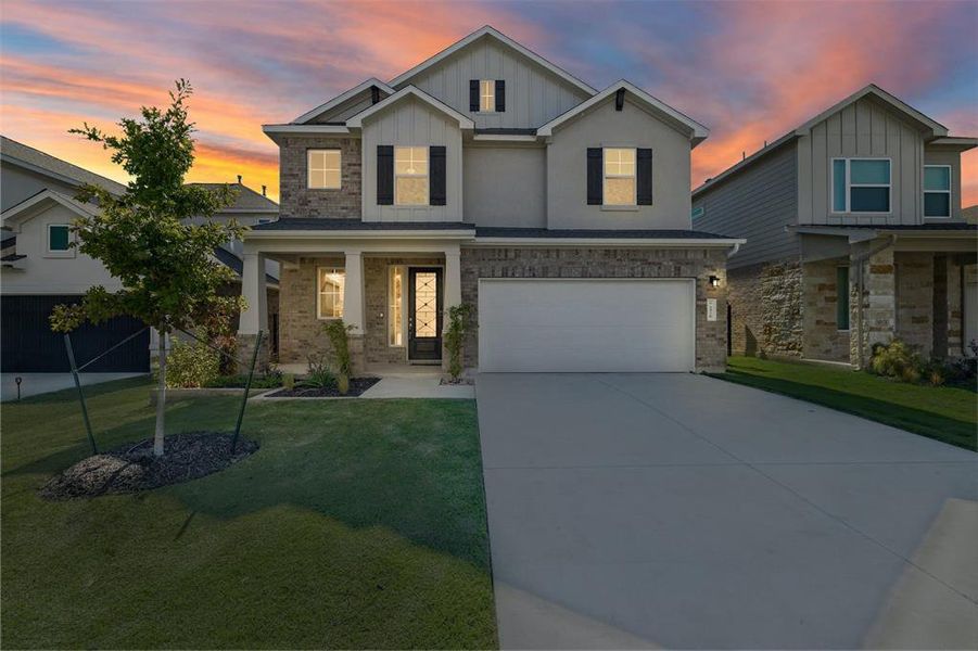 Craftsman house with board and batten siding, a porch, a lawn, driveway, and brick siding Craftsman house with board and batten siding, a porch, a lawn, driveway, and brick siding