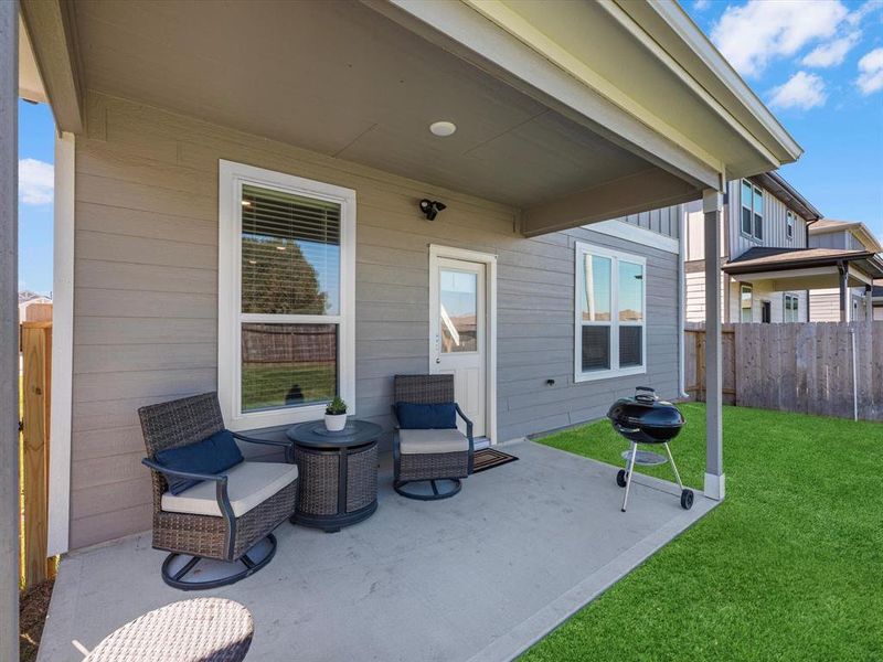 The covered patio is generously sized, providing ample space for various outdoor activities.