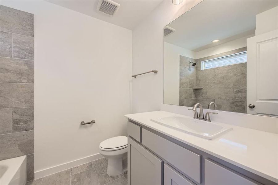 Bathroom with toilet, vanity, and baseboards Bathroom with toilet, vanity, and baseboards
