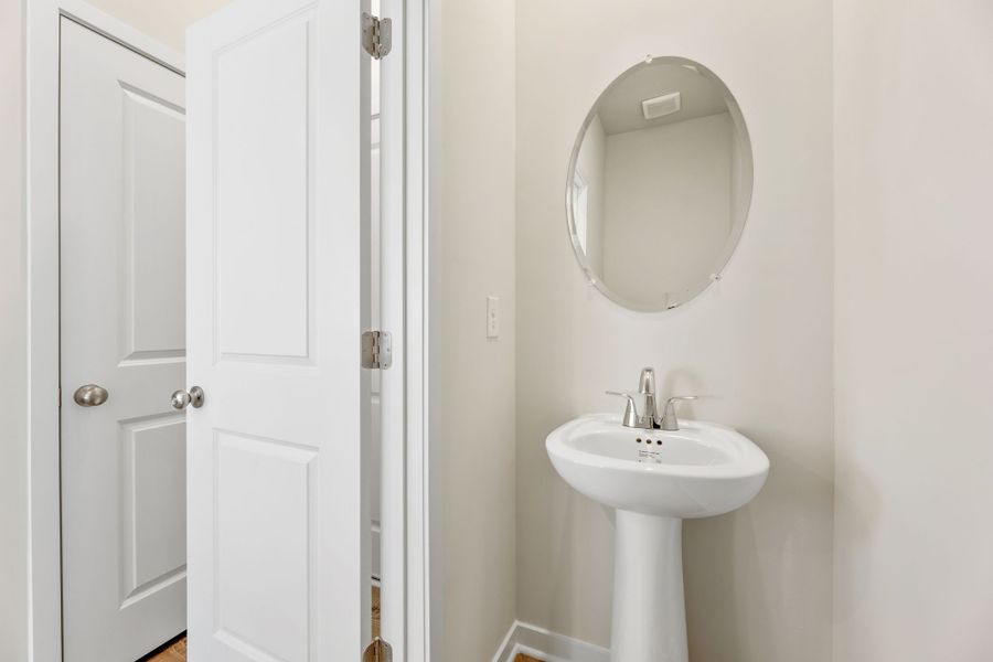A bathroom with a round mirror.