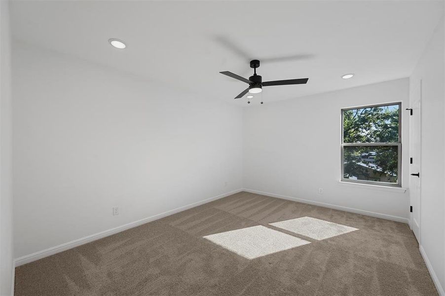 Spare room featuring carpet and ceiling fan