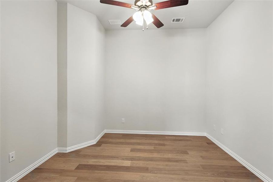 Unfurnished room with wood finished floors and a ceiling fan