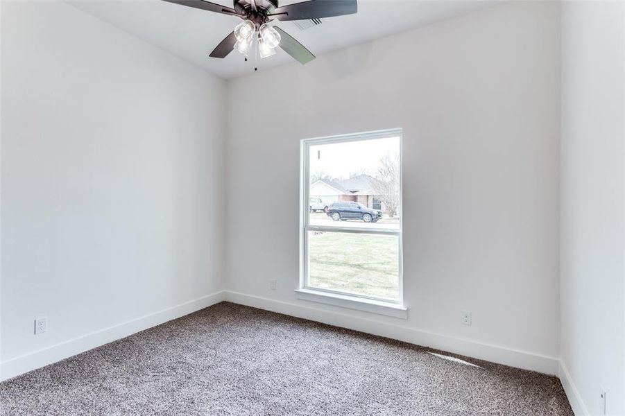 Empty room with carpet floors, plenty of natural light, and baseboards