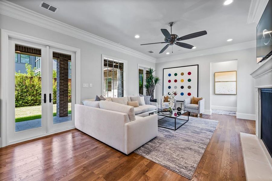 Living room featuring hardwood / wood-style floors, crown molding, and ceiling fan