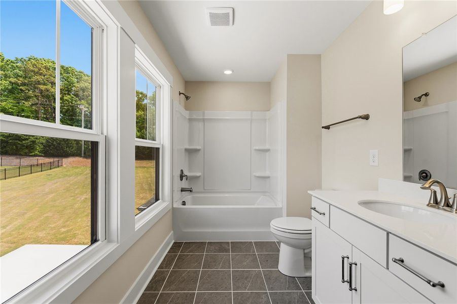 A well-lit bathroom, featuring a vanity with a sle