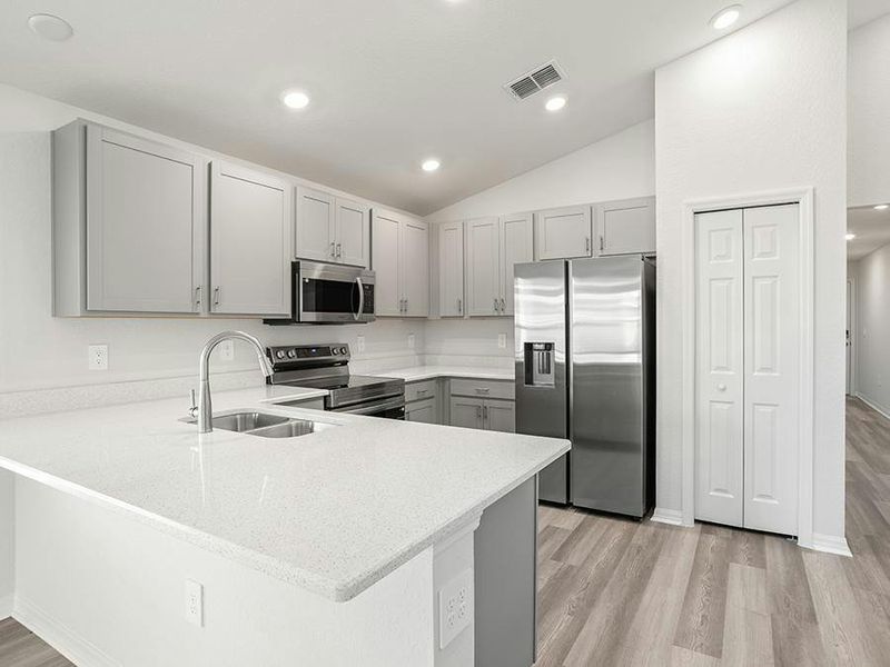 This home features a bright, open kitchen with quartz, 36-inch cabinets, Samsung SS appliances, and a pantry.
