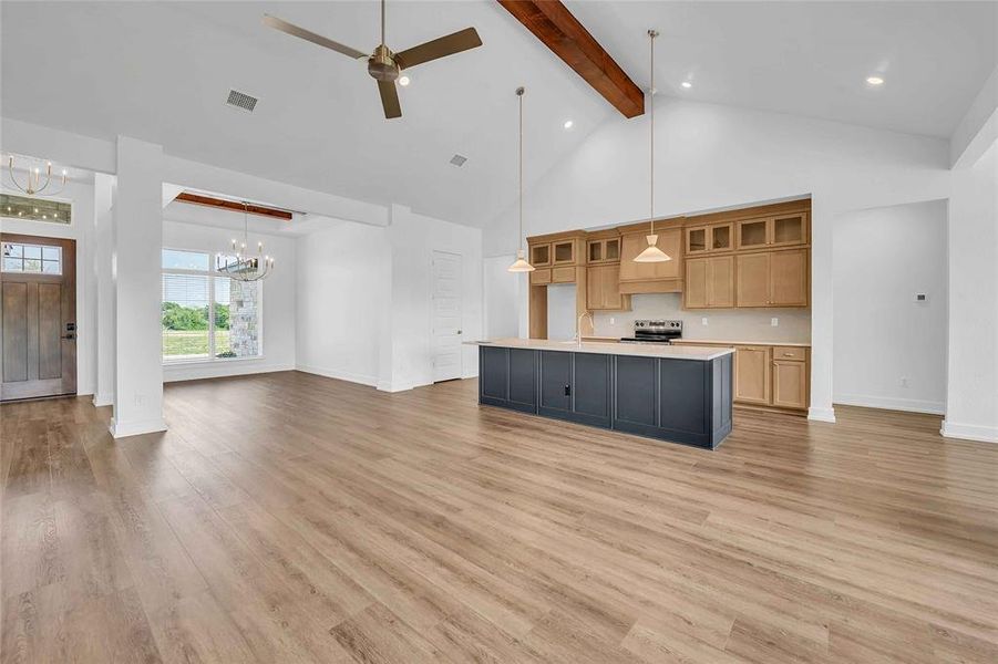 Kitchen with electric range, light countertops, high vaulted ceiling, beamed ceiling, and visible vents Kitchen with electric range, light countertops, high vaulted ceiling, beamed ceiling, and visible vents