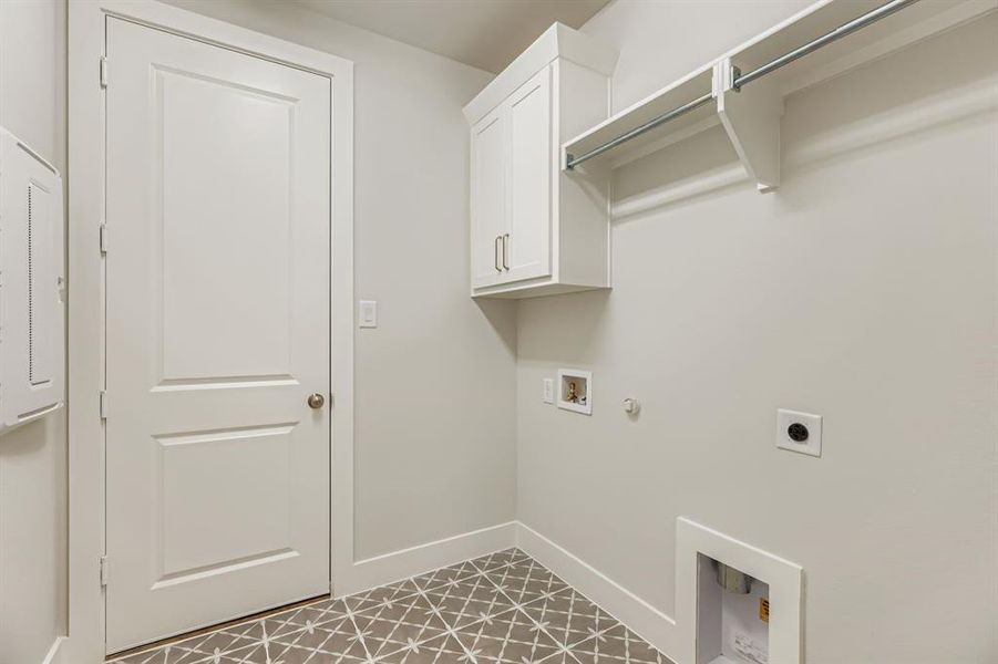 Washroom with hookup for a gas dryer, hookup for a washing machine, electric dryer hookup, cabinet space, and light tile patterned floors