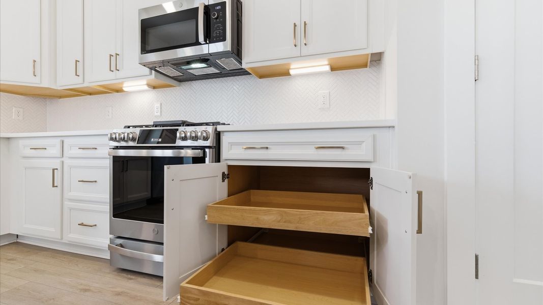 Tasteful kitchen with plenty of storage space and modern finishes in a first-class DRB Homes design at the Foxbank community