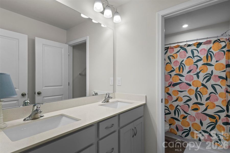 Shared full bathroom with private toilet/shower and dual vanities. Shared full bathroom with private toilet/shower and dual vanities.