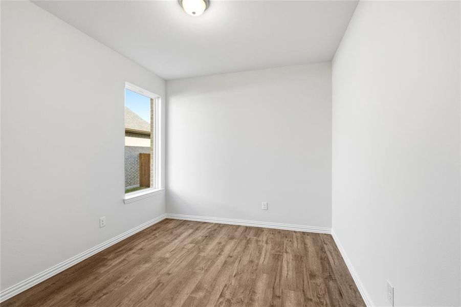 Office with wood laminate flooring.
