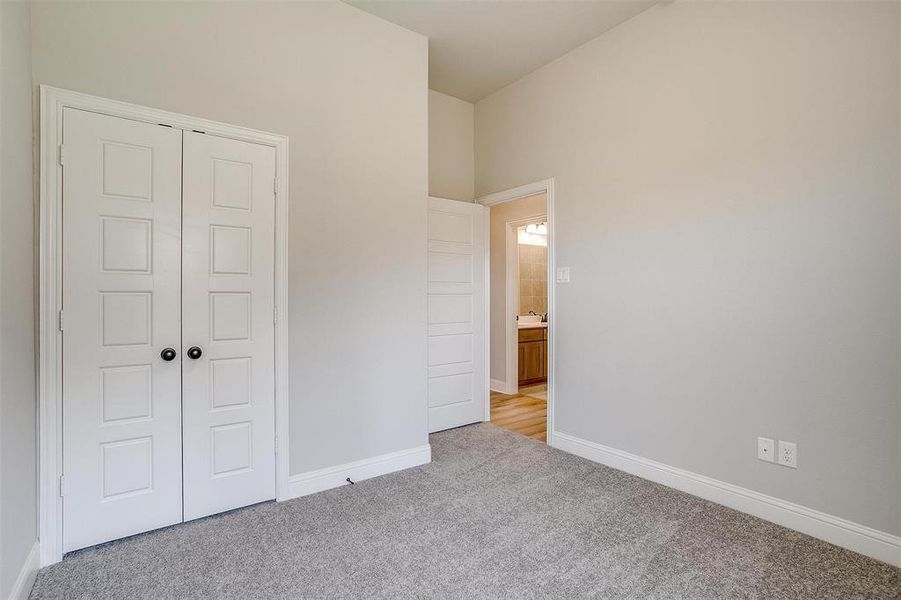 Unfurnished bedroom with light colored carpet and a closet