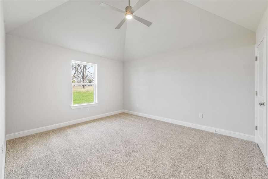 Spare room with light colored carpet, high vaulted ceiling, and a ceiling fan