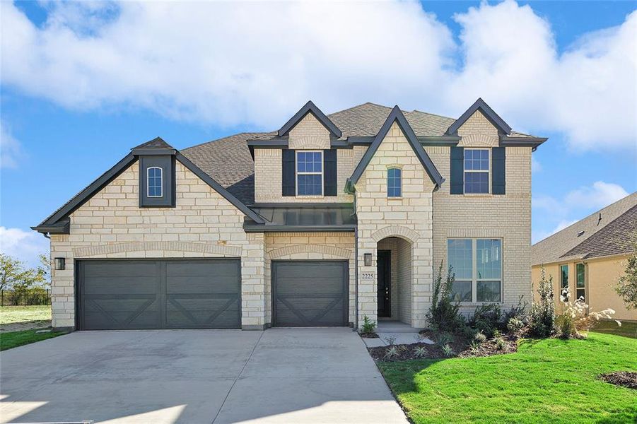 View of front of home featuring a front yard and a garage