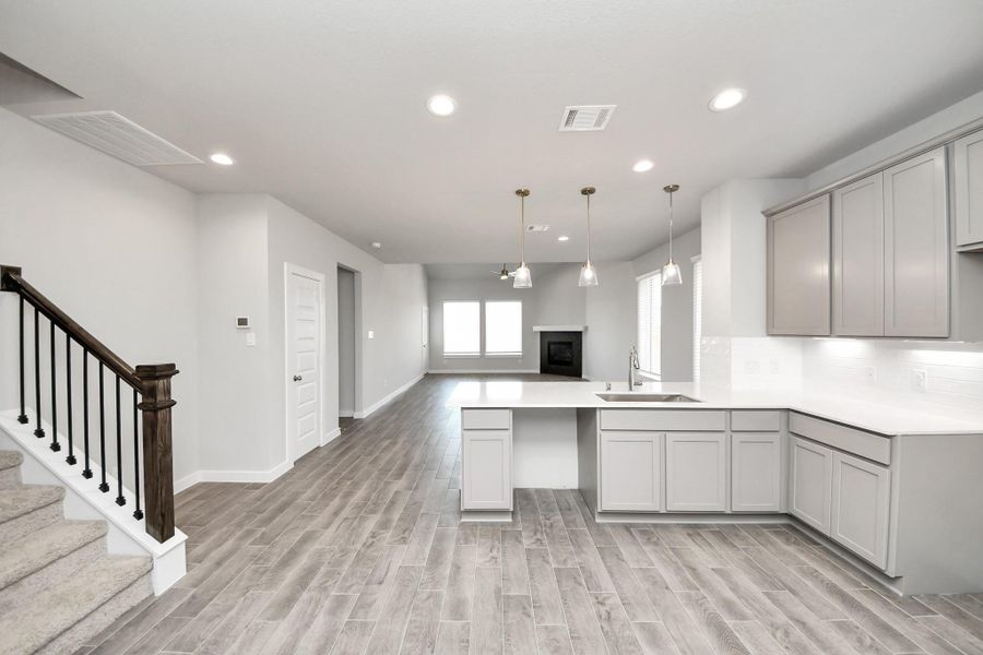 Discover another perspective of this stunning kitchen, generously appointed with an abundance of counter space. Sample photo of completed home with similar floor plan. Actual colors and selections may vary.