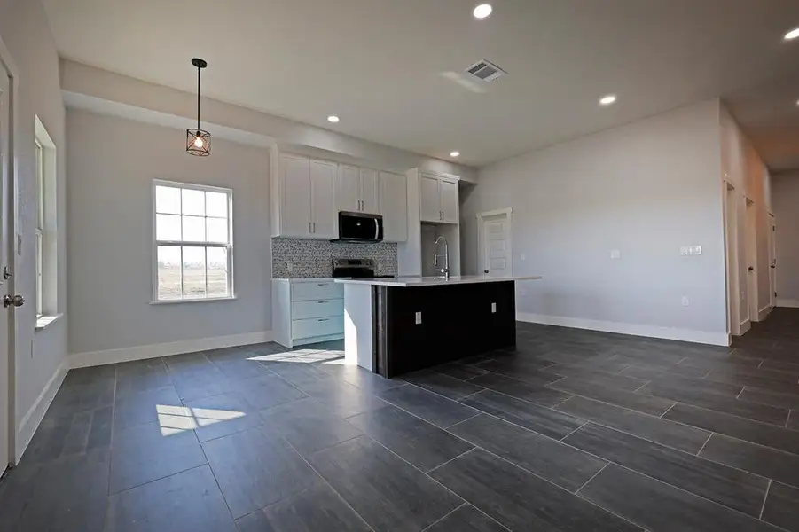 Kitchen with white cabinets, tasteful backsplash, recessed lighting, appliances with stainless steel finishes, and a center island with sink Kitchen with white cabinets, tasteful backsplash, recessed lighting, appliances with stainless steel finishes, and a center island with sink
