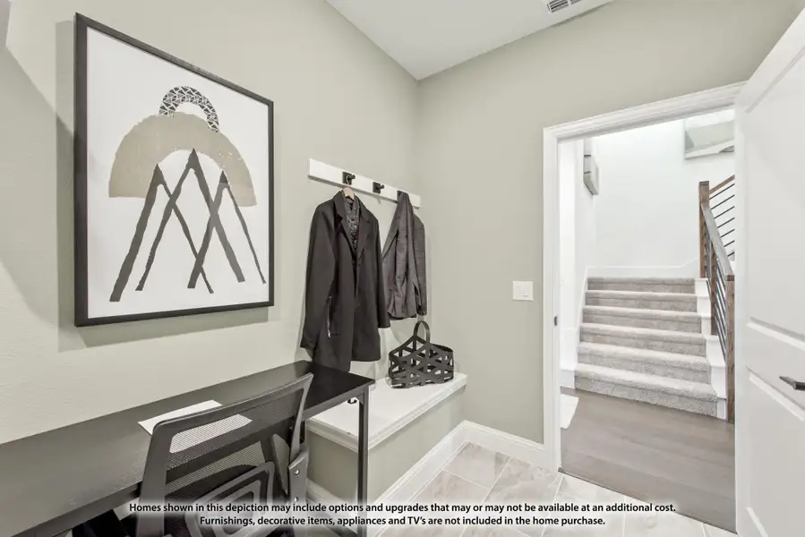 Mudroom entry with wall-mounted coat hooks, built-in bench, and small desk area with staircase visible through doorway Mudroom entry with wall-mounted coat hooks, built-in bench, and small desk area with staircase visible through doorway