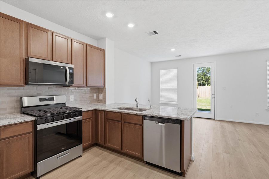 Additional view of kitchen overlooking the dining area and the backyard green space. Additional view of kitchen overlooking the dining area and the backyard green space.