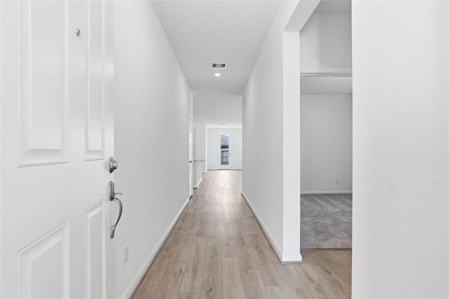 Welcome inside this lovely home of 3007 Cronus Way! This bright and welcoming entry features recessed lighting, bright neutral tone paint, and gorgeous Layton Lake vinyl plank flooring in Soft Beige.
