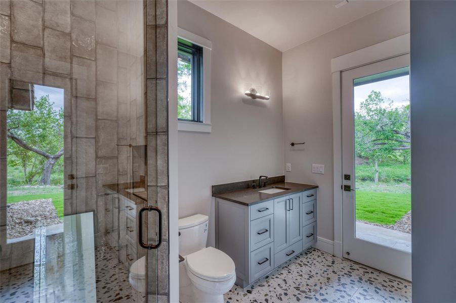 Full bath with toilet, a stall shower, and vanity