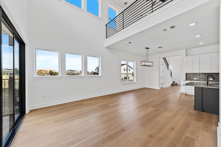 High ceilings in living area with natural light and access to sliders to outdoor deck and yard
