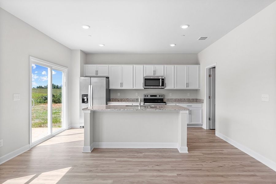 A kitchen with white cabinets.