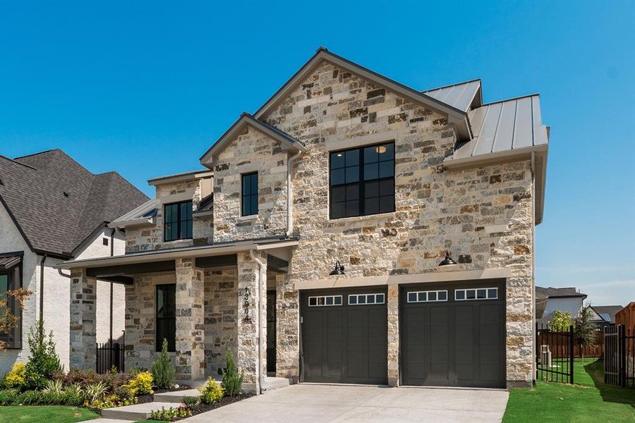 View of front of home with a garage and stone siding