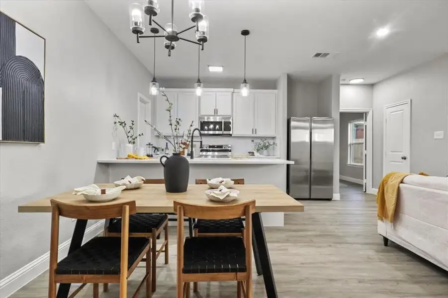 Dining space featuring light hardwood / wood-style flooring, a notable chandelier, and sink