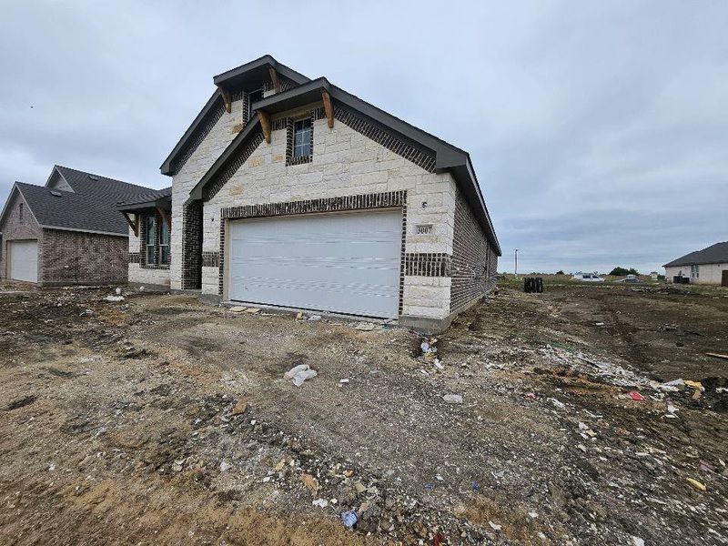 Stone and brick-clad exterior with a prominent two-car garage Stone and brick-clad exterior with a prominent two-car garage