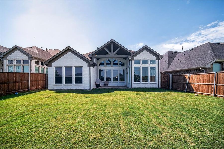 Rear view of house with a patio, brick siding, and a fenced backyard Rear view of house with a patio, brick siding, and a fenced backyard