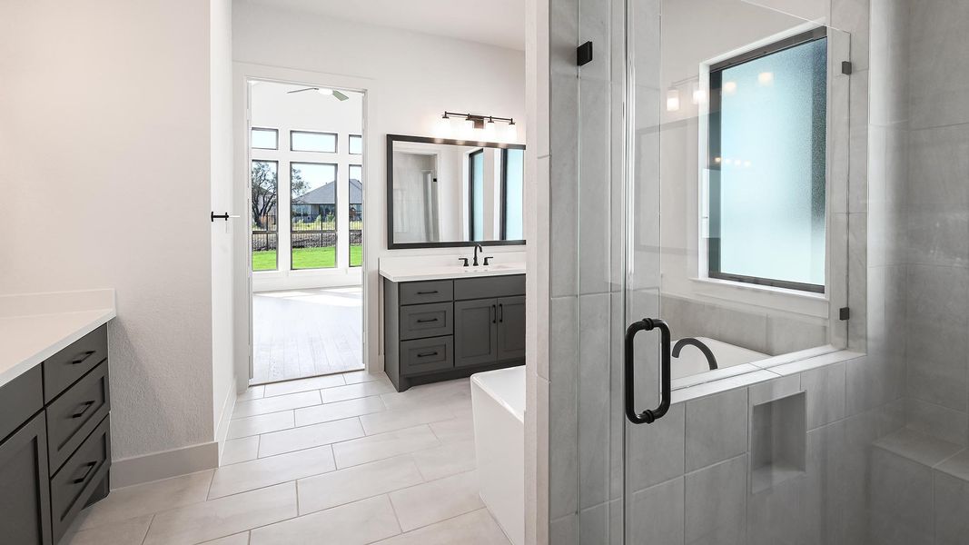 Full bathroom featuring vanity, a freestanding tub, a stall shower, and light tile patterned floors Full bathroom featuring vanity, a freestanding tub, a stall shower, and light tile patterned floors