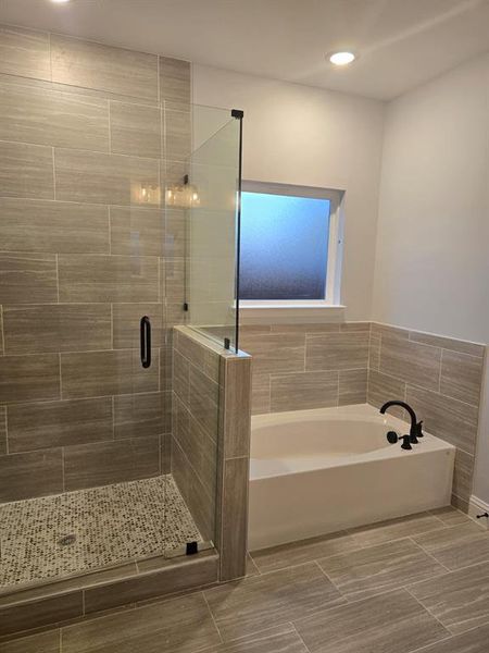 Bathroom featuring tile patterned flooring and shower with separate bathtub