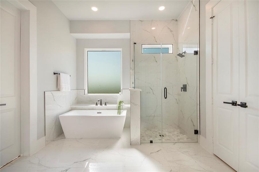 Bathroom featuring marble tiled flooring, a soaking tub, a marble finish shower, recessed lighting, and tile walls Bathroom featuring marble tiled flooring, a soaking tub, a marble finish shower, recessed lighting, and tile walls