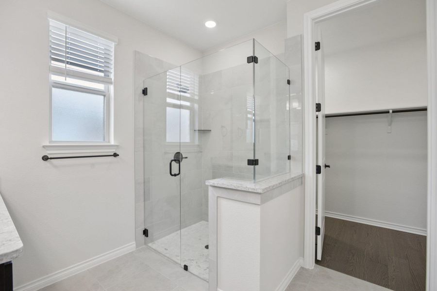 Bathroom featuring a stall shower, a walk in closet, light tile patterned floors, and recessed lighting