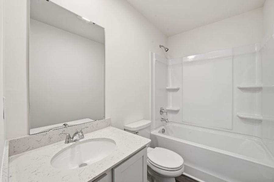 A bathroom with a sink toilet and bathtub.