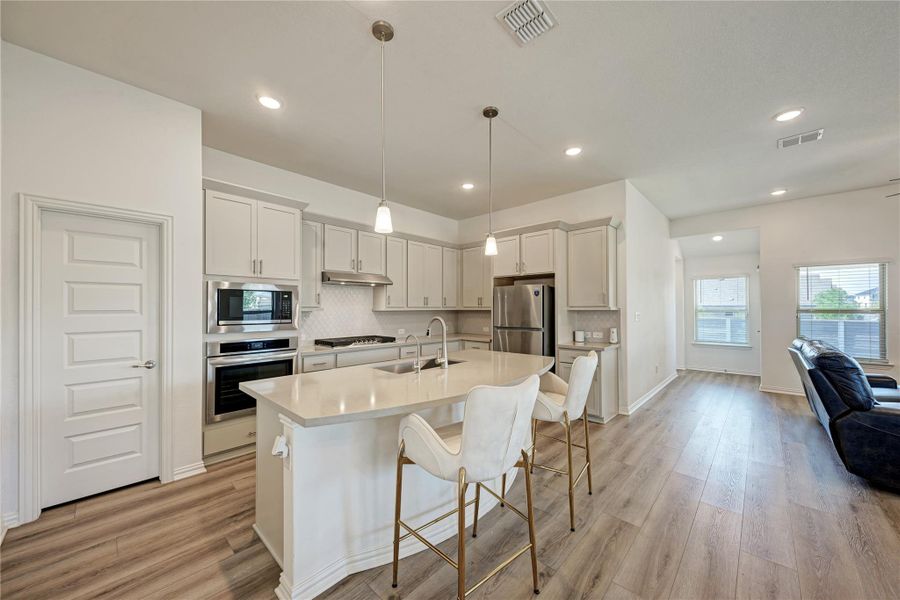 A well-appointed kitchen features a large island and ample cabinet space, seamlessly connecting to the living area.