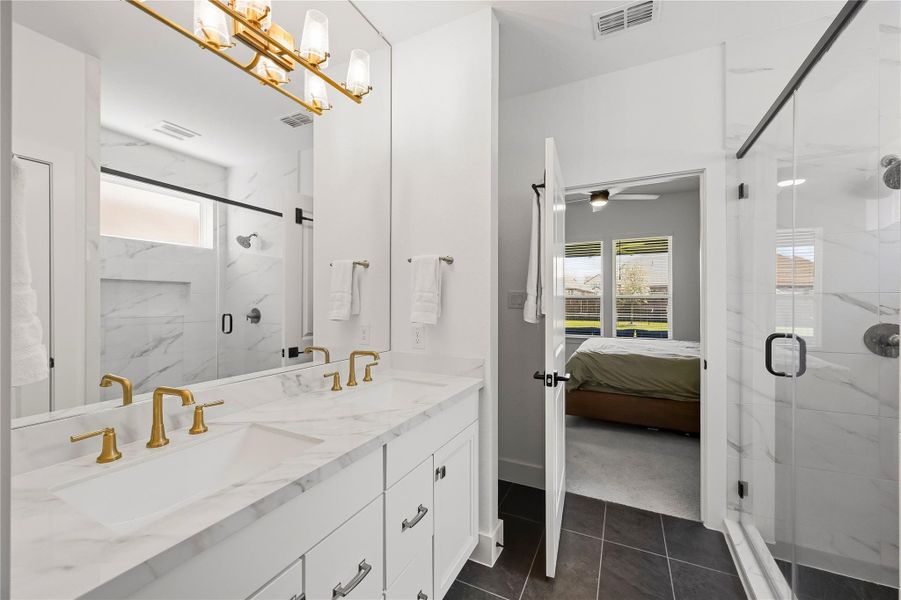 Elegant gold plumbing fixtures bring a warm, sophisticated finish to the primary bath, complementing the space with a distinctive touch of luxury. Elegant gold plumbing fixtures bring a warm, sophisticated finish to the primary bath, complementing the space with a distinctive touch of luxury.