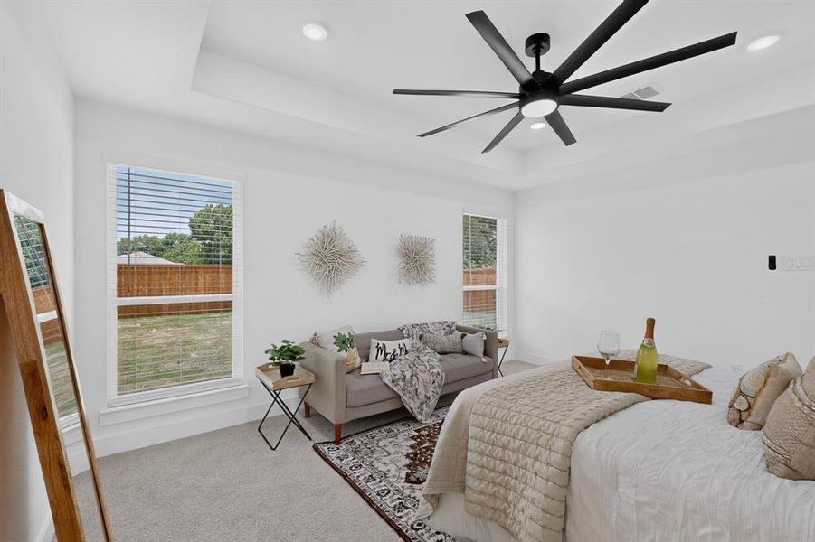 Spacious room featuring a tray ceiling with a modern black ceiling fan, recessed lighting, and light gray carpeting