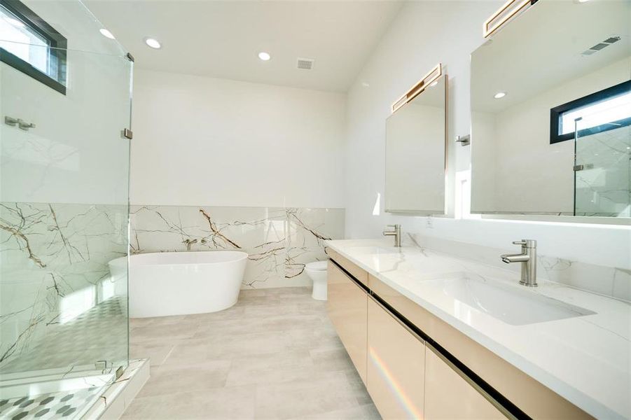 Full bathroom featuring separate shower and tub, tile walls, toilet, vanity, and tile patterned floors