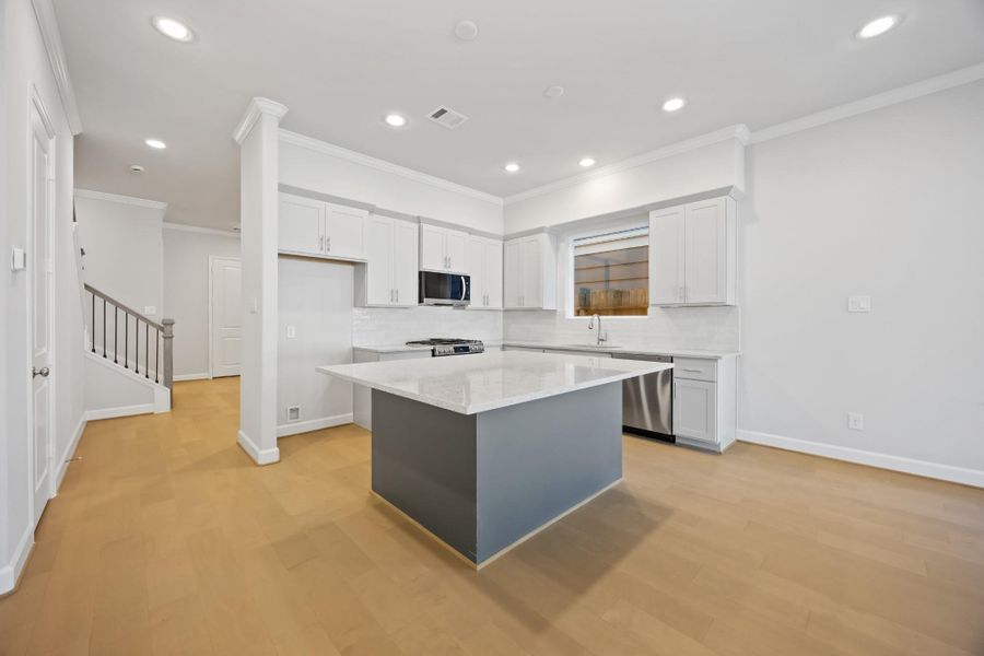 An alternate view unveils the kitchen’s grand island, serving as the heart of the home, with an inviting passage to the adjacent dining room, where memories await to be made. An alternate view unveils the kitchen’s grand island, serving as the heart of the home, with an inviting passage to the adjacent dining room, where memories await to be made.