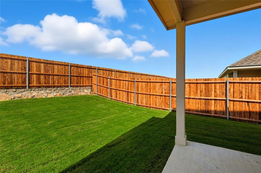 Fenced backyard with a patio area Fenced backyard with a patio area